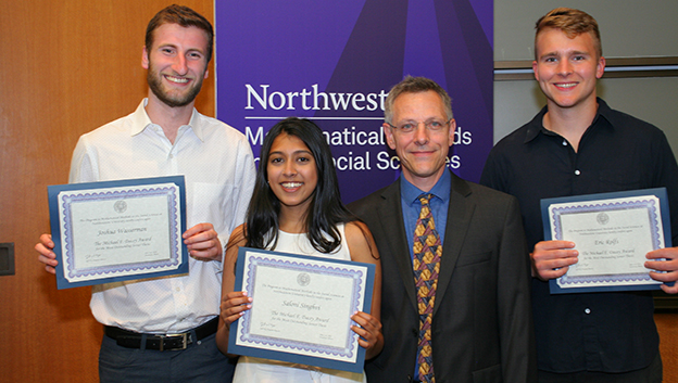 three students and professor with award certificate